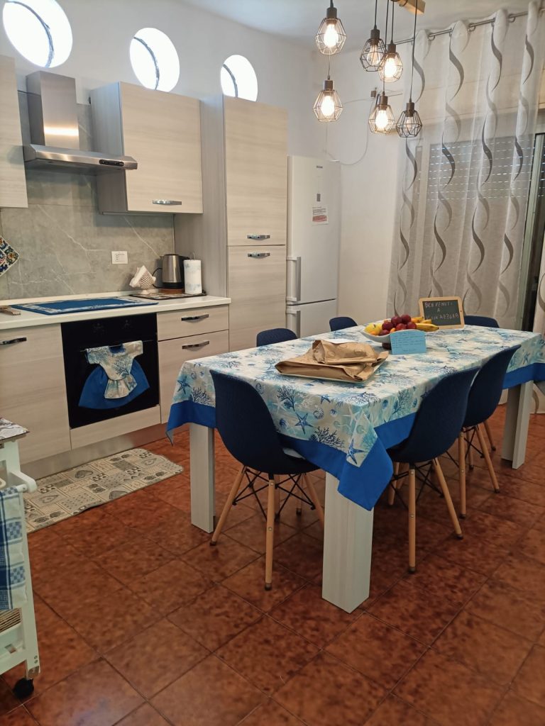 🇮🇹 IT Cucina attrezzata con tavolo centrale apparecchiato e decorazione mediterranea 🇬🇧 EN Equipped kitchen with central dining table and Mediterranean-style decoration 🇩🇪 DE Ausgestattete Küche mit zentralem Esstisch und mediterraner Dekoration 🇫🇷 FR Cuisine équipée avec table centrale et décoration méditerranéenne 🇨🇿 CZ Vybavená kuchyně se středovým stolem a středomořskou výzdobou 🇧🇬 BG Оборудвана кухня с централен маса и средиземноморски декор 🇵🇱 PL Kuchnia z wyposażeniem, centralnym stołem i śródziemnomorską dekoracją 🇧🇪 NL Volledig uitgeruste keuken met centrale tafel en mediterrane sfeer 🇹🇷 TR Akdeniz tarzı dekorasyonlu, donanımlı mutfak ve orta yemek masası 🇬🇷 GR Πλήρως εξοπλισμένη κουζίνα με κεντρικό τραπέζι και μεσογειακή διακόσμηση 🇵🇹 PT Cozinha equipada com mesa central e decoração de estilo mediterrânico 🇪🇸 ES Cocina equipada con mesa central y decoración de estilo mediterráneo